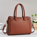 Detailed macro of brown pebble leather handbag featuring heart accents and gold lettering - Earthy Yellow