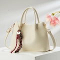 Détail du sac à main beige élégant avec texture grainée et pendentif clé décoratif - 25*9*18 / Blanc Cassé