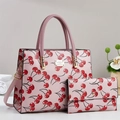 Detailansicht der rosa Handtasche mit Kirschmuster und passender Geldbörse mit Gold-Hardware - Rosa
