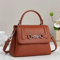 Detailed view of ginger crossbody bag showing premium lychee texture and silver horsebit buckle - Earthy Yellow