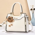 Elegante borsa a mano beige intrecciata con finiture dorate e ciondolo a orsetto - Bianco Sporco