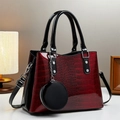 Dettaglio borsa con texture coccodrillo bordeaux lucido e accenti in metallo argento - Borgogna