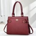 Close-up of wine red litchi grain leather tote bag with elegant gold hardware details - Burgundy