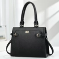 Detail of black pebbled leather tote bag featuring gold twist-lock and side strap accents - Black