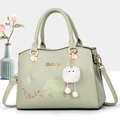 Elegant mint green embroidered handbag with floral butterfly motifs and plush charm - Dark Green