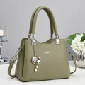 Detail of olive green pebbled leather handbag with pearl shell charm and metal hardware - Green