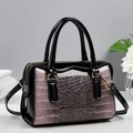 Détail de la texture crocodile rose et du cuir verni noir sur le sac à bandoulière - Rose