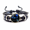 Macro detail of Pisces zodiac multilayer braided leather bracelet with blue glass cabochon - Pisces