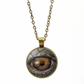 Gros plan détaillé du pendentif œil de dragon en bronze avec cabochon en verre sur chaîne - Bronze