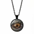 Détail macro du pendentif cabochon en verre avec un motif réaliste d'œil de dragon - Noir