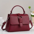 Close-up of wine red litchi grain leather bag with silver metal ring and pleated detail - Burgundy