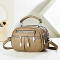Close-up of litchi-textured brown crossbody bag with multi-layer zipper pockets - Khaki