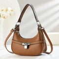Détail d'un sac demi-lune en cuir litchi marron avec boucle argentée et ombre douce - Marron