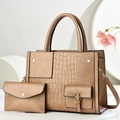 Close-up of brown crocodile embossed tote bag with matching envelope clutch on white stand - Khaki
