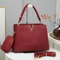 Close-up of wine red lychee leather texture and gold V-shaped logo on the handbag - Burgundy