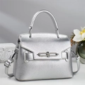 Close-up of silver pebble leather handbag with premium metallic twist lock detail - Silver