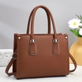 Detalle de bolso tote en cuero granulado marrón con anillas de metal plateado - Marrón