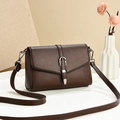 Brown lychee leather shoulder bag with silver U-shaped buckle on a white table - Brown