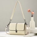 Classic cream pebble leather shoulder bag with black metal clasp on stone display - Off White