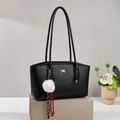 Black pebbled leather tote bag with gold bow clasp and plush pendant on pedestal - Black
