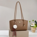 Detail of brown litchi pattern leather tote bag with gold bow and white plush charm - Brown