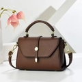 Detalle de bolso marrón con textura litchi, cierre metálico dorado y correa ajustable - café