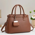 Detailed view of brown lychee grain leather handbag with dual handles and mini pouch - Earthy Yellow