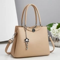 Detail of beige lychee leather tote bag with silver hardware and floral charm - Khaki