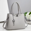 Light gray pebbled leather large tote handbag with floral metal pendant and shoulder strap - Gray