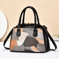 Detailoverzicht van vintage patchwork handtas met getextureerd leer en gouden hardware - Grijs