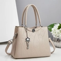 Borsa beige con goffratura a cuore e ciondolo floreale su sfondo minimalista - Albicocca
