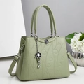 Dettaglio borsa in pelle martellata verde chiaro con cuori goffrati e ciondolo a fiore - Verde