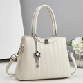 Close-up of ivory handbag with honeycomb embossed texture and flower metal charm - Off White
