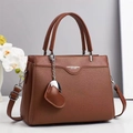 Brown litchi grain leather handbag for women with adjustable strap and heart pendant - Earthy Yellow
