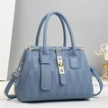 Dettaglio della borsa tote blu in pelle martellata con hardware dorato e righe a rilievo - Blu