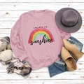 Flat lay of pink sweatshirt with rainbow You Are My Sunshine print on white wood - S / Pink (Black Letters)