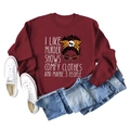 Detail view of burgundy crewneck sweatshirt with cartoon graphic and casual lifestyle props - Burgundy