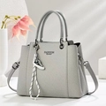 Detail view of grey textured leather tote with Fashion Queen print and sneaker charm - Gray