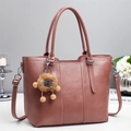 Dettaglio della borsa tote grande in pelle malva con manici rinforzati e ciondolo - Rosa