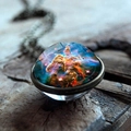 Macro view of double-sided glass galaxy pendant with cosmic nebula on rustic wood - Pillars Of Creation Nebula Style (JY001624-3)