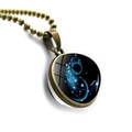 Detailed macro view of Aquarius zodiac sign pendant with glass cabochon and bronze chain - Bronze-Aquarius