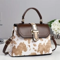 Detalle del bolso bandolera marrón de moda con estampado de vaca y hebilla de metal dorado - Estampado de Vaca Albaricoque