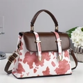 Chic cow print top-handle bag with white and pink patterns and brown shoulder strap - Pink