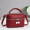 Detail view of red lychee pattern handbag with silver zippers and adjustable strap - Burgundy