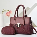 Two-piece burgundy handbag set with snakeskin texture and metal lock in minimal studio setting - Burgundy