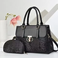 Detail of black faux crocodile leather tote bag set with golden metal hardware and strap - Black