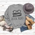 Flat lay of gray Book Nerd sweatshirt styled with autumn accessories on white wood - S / Grey (Black Font)