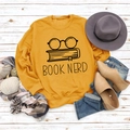 Flat lay of a mustard yellow sweatshirt with Book Nerd glasses print and autumn styling - S / Yellow (Black Font)