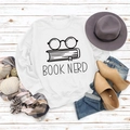 Flatlay des weißen Book Nerd Sweatshirts mit Brillenprint und Herbst-Accessoires - S / Weiß (Schwarze Schrift)