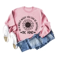 Pink crewneck sweatshirt with sunflower print and Be Kind slogan paired with blue jeans - Pink Sweatshirt (Black Text Pattern)